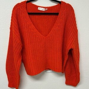 Cropped sweater in an orangey-red color